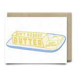Anvil Cards' Nobody Butter Birthday Card features two butter sticks ("Ain't Nobody Butter" and "Happy Birthday") on a plate, with a brown envelope. The A2 card is beautifully printed on linen paper and blank inside for your message.