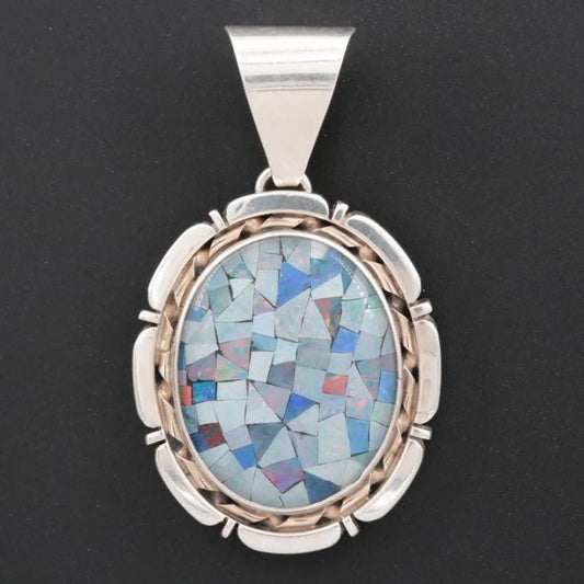 The Vintage Opal Pendant features an oval mosaic with blue, purple, and chip opal tiles set in sterling silver against a black background in a decorative metal frame.