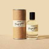 A bottle of Pinyon Pine by Saguara Perfumes, handmade in California, is displayed beside its cylindrical cardboard packaging against a beige background.