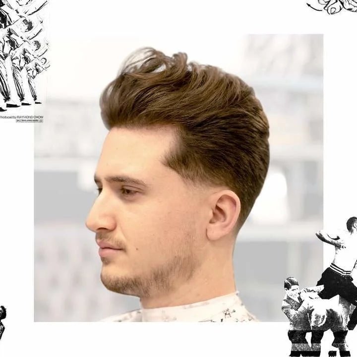 A man with neatly styled, voluminous brown hair and a trimmed beard is shown in profile against a light background, his look enhanced by Salt Spray | Uppercut Deluxe from Uppercut Deluxe for textured hold.