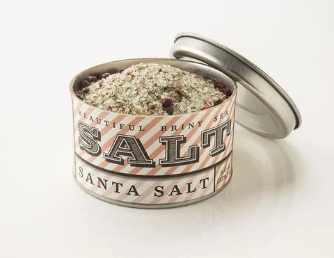 A tin of Santa Sea Salt by Beautiful Briny Sea sits open on a white surface, showing its coarse seasoning blend with organic rosemary and pink peppercorn.