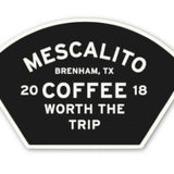 A black and white badge-shaped "Shop Stickers | Mescalito Coffee" from Mescalito Coffee reads: "Mescalito Brenham, TX 2018 Coffee Worth the Trip," reflecting classic coffee shop vibes in this charming small town spot.