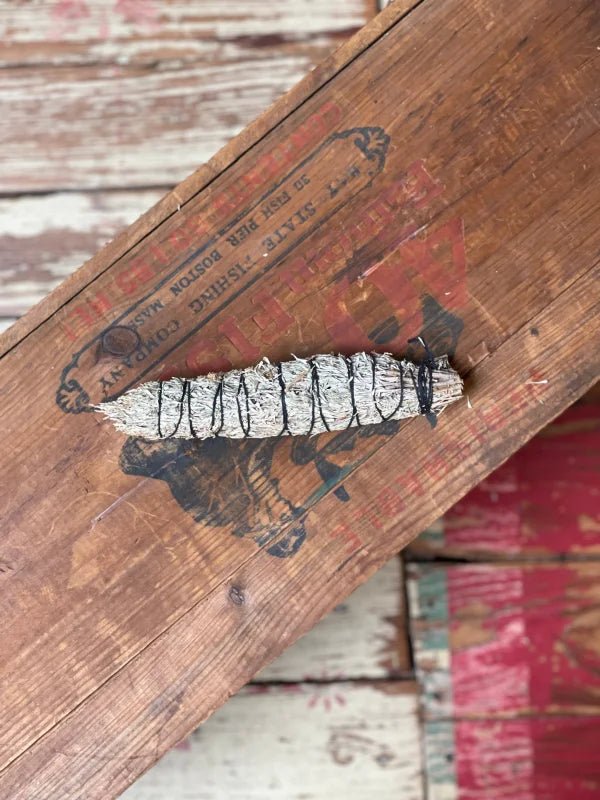 The Smudge Stick | New Mexico High Desert Pinon by Taos Herb Co rests on a weathered wooden surface, ready to bring tradition and tranquility to your home.