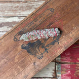 The Smudge Stick | Sage and Cedar from Taos Herb Co rests on a weathered wooden surface with faded paint, evoking the timeless traditions of Taos Pueblo.
