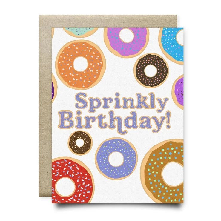 The "Sprinkly Birthday Card" by Anvil Cards features colorful donut illustrations and "Sprinkly Birthday!" on linen A2 paper. Blank inside, it comes with a brown envelope.
