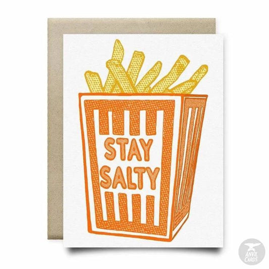 The Stay Salty Card by Anvil Cards features a box of French fries with "STAY SALTY" on the front, printed on linen A2 paper, blank inside for your message, with a plain background and envelope.