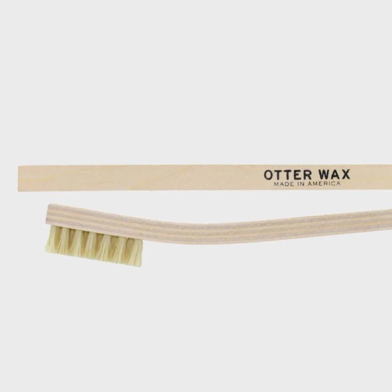 The Otter Wax Tampico Cleaning Brush features natural light bristles and a wooden handle printed with "Otter Wax Made in America," ideal for cleaning leather or fabric, displayed on a plain white background.