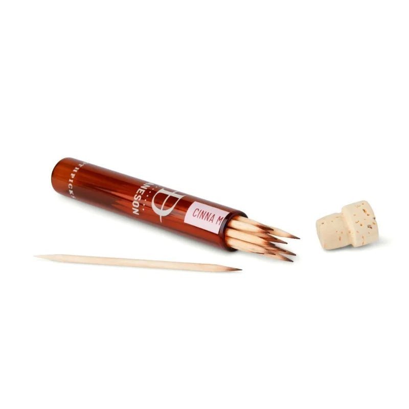An open cylindrical Daneson container with a cork lid holds several Toothpick | CinnaMint No. 7 toothpicks, with one resting outside.