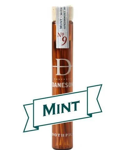 A glass vial labeled “Daneson Toothpick | Mint No. 09” holds essential oil-infused toothpicks with a cool mint flavor, featuring a "MINT" banner on the front.