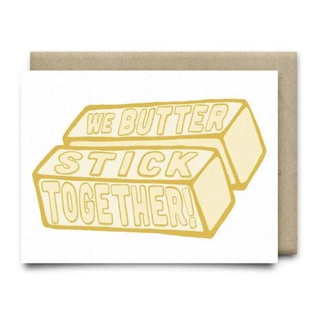 We Butter Stick Together | Anvil Cards by Anvil Cards features two butter sticks with “We butter stick together!” text, set against a brown envelope. Printed on premium linen A2 card—perfect for sending love from Houston, Texas.