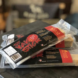 Three Yak Stick | Rogue Pet Feed dog chews are stacked on a dark surface, featuring Rogue Pet Feed branding. These high protein treats are ideal for rewarding your pup.