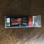 A large Yak Stick dog chew from Rogue Pet Feed, a high-protein treat, is shown on a brown leather surface.